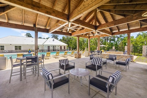 Shaded outdoor seating by the pool at Capital Grand Apartments in Tallahassee, FL