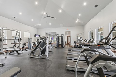 A fitness center with treadmills, weights, and strength training equipment at Creekside on Parmer Lane Apartments in Austin, TX