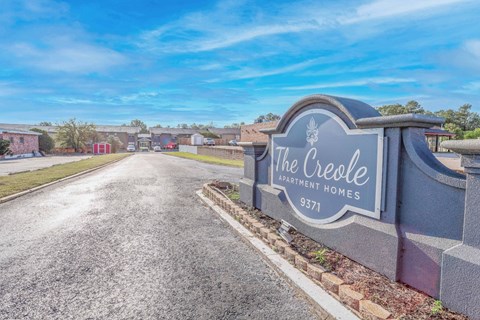 A stone sign for "The Creole Apartment Homes" is at the entrance to The Creole Apartments in Shreveport, LA