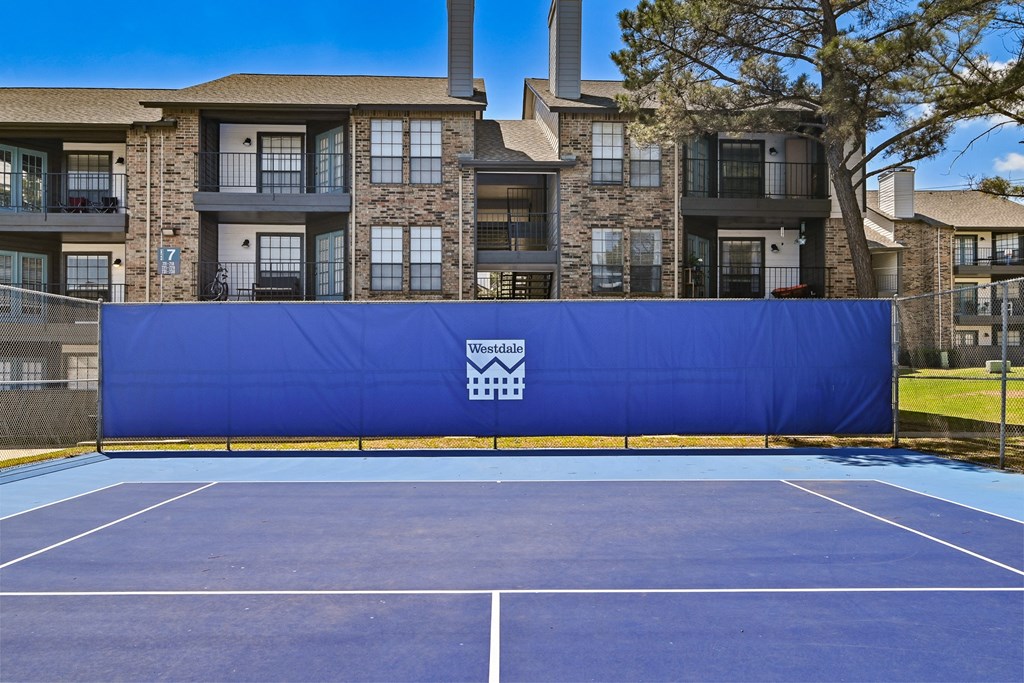 an outdoor tennis court at the enclave at woodbridge apartments in sugar land, tx