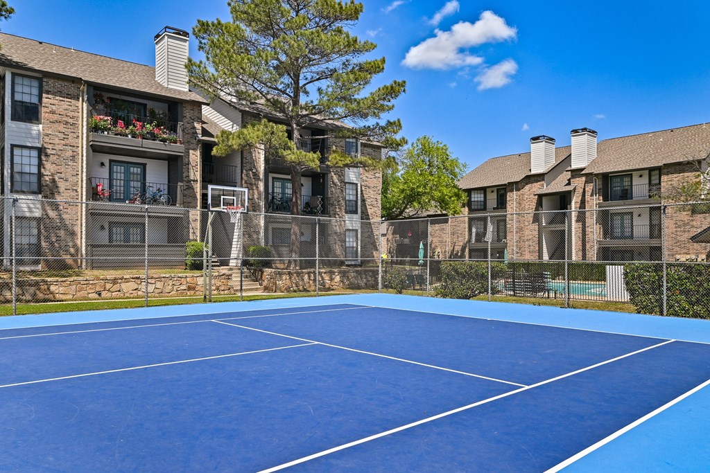 an outdoor tennis court at the enclave at woodbridge apartments in sugar land, tx