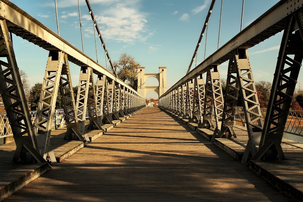 A long metal bridge with a wooden walkway.