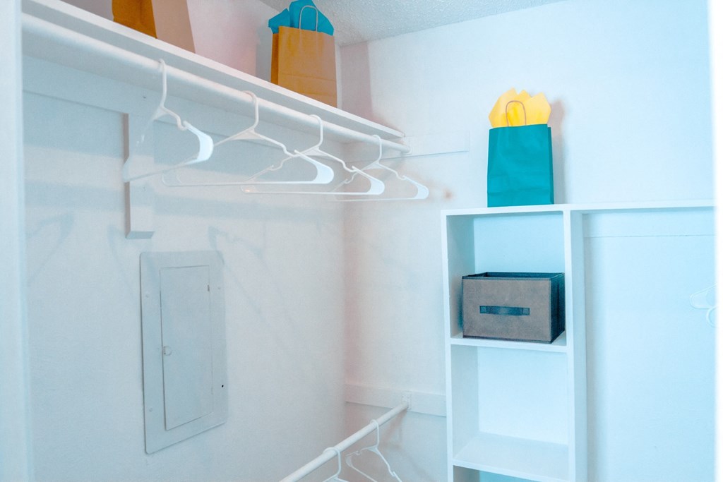 Model walk-in closet with built-in white shelves at Chisholm Place Apartments in Plano, TX