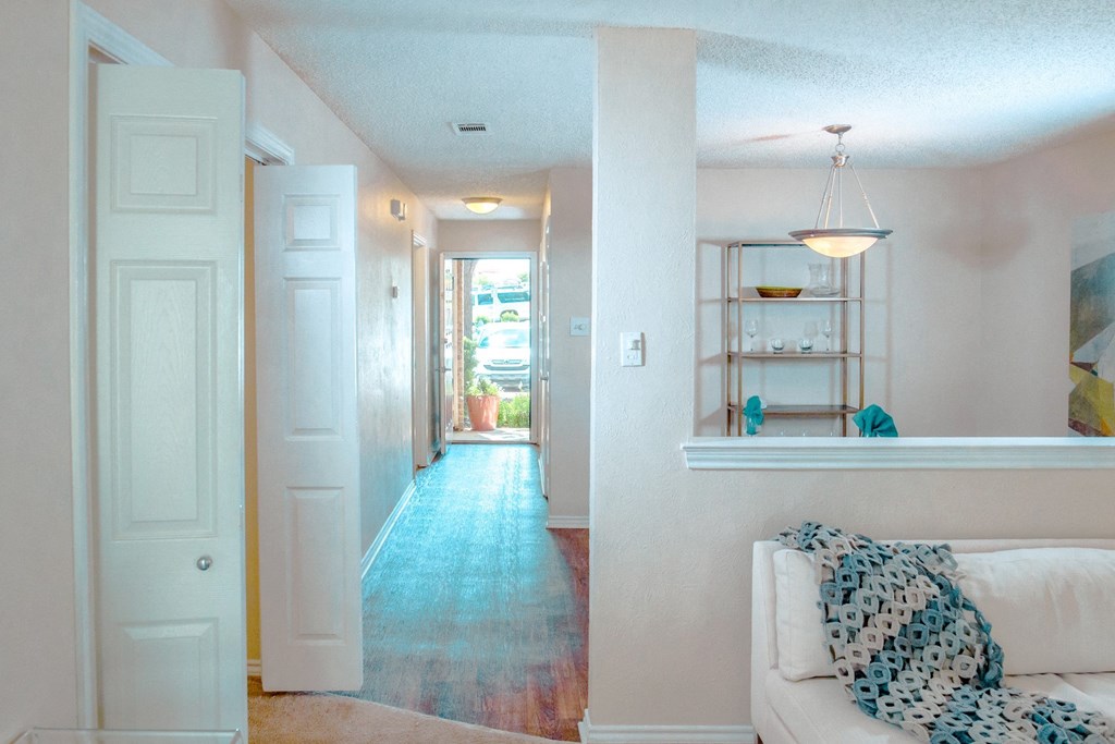 Model view of living room and a hallway to entrance at Chisholm Place Apartments in Plano, TX