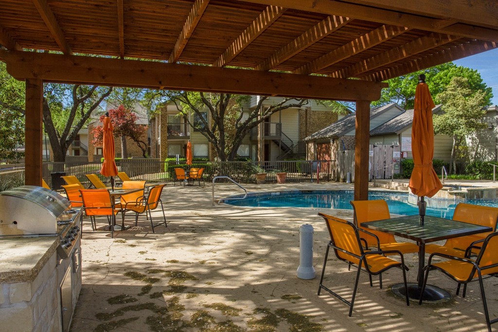 Pool area with grilling station at Chisholm Place Apartments in Plano, TX