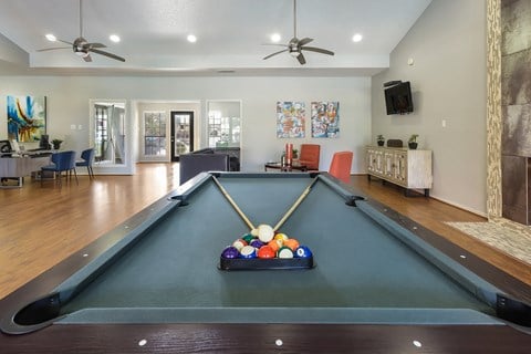 a pool table with a bunch of balls on it in the center of a room