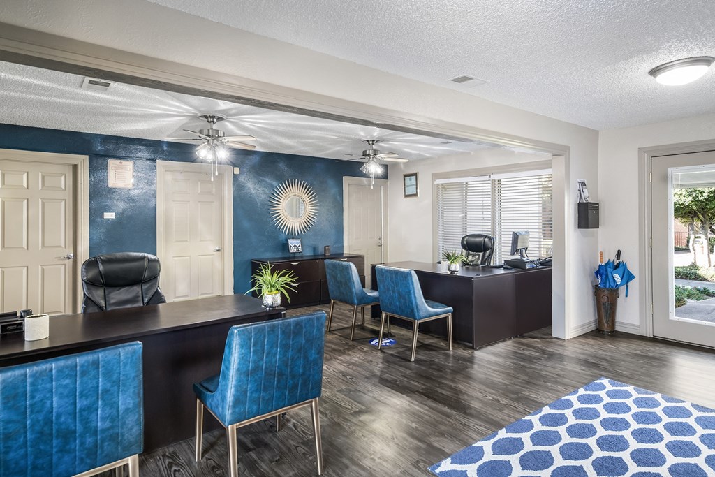 a living room and kitchen with blue chairs and a counter