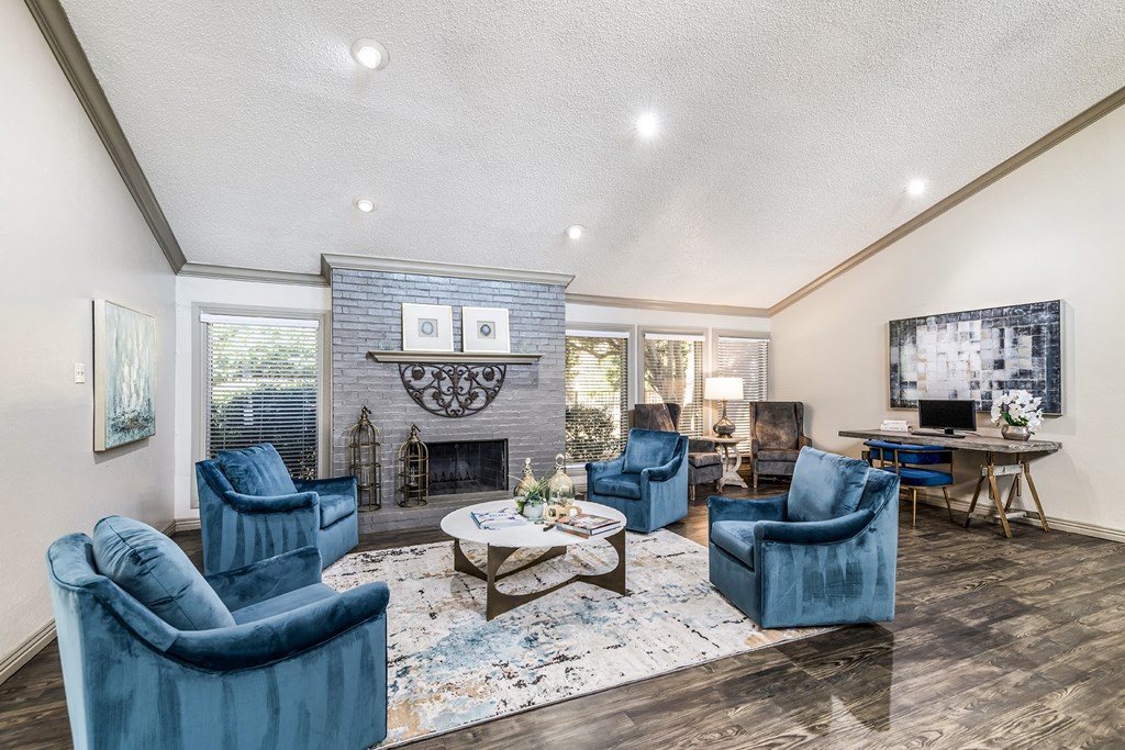 a living room with blue chairs and a fireplace