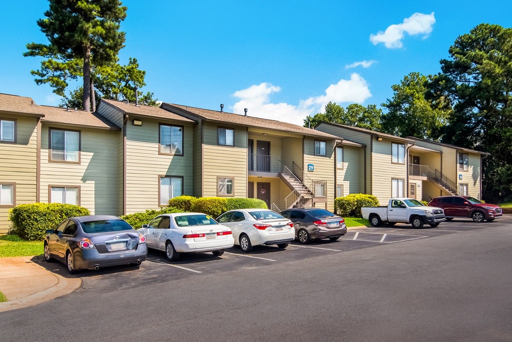 an apartment building with cars parked in a parking lot