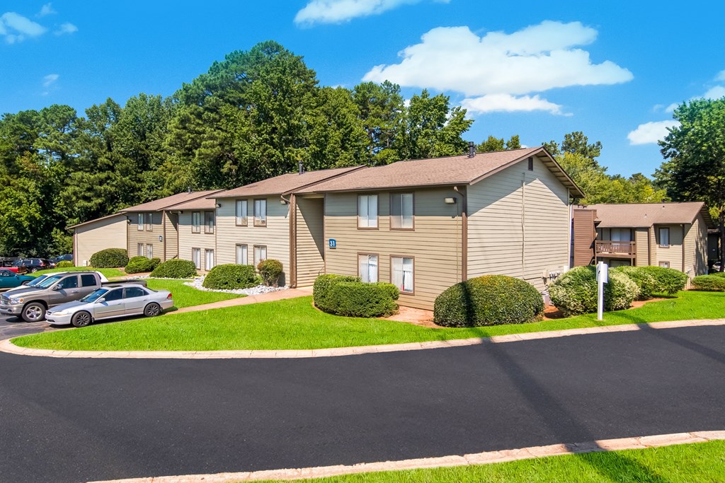 an apartment building with cars parked in a parking lot