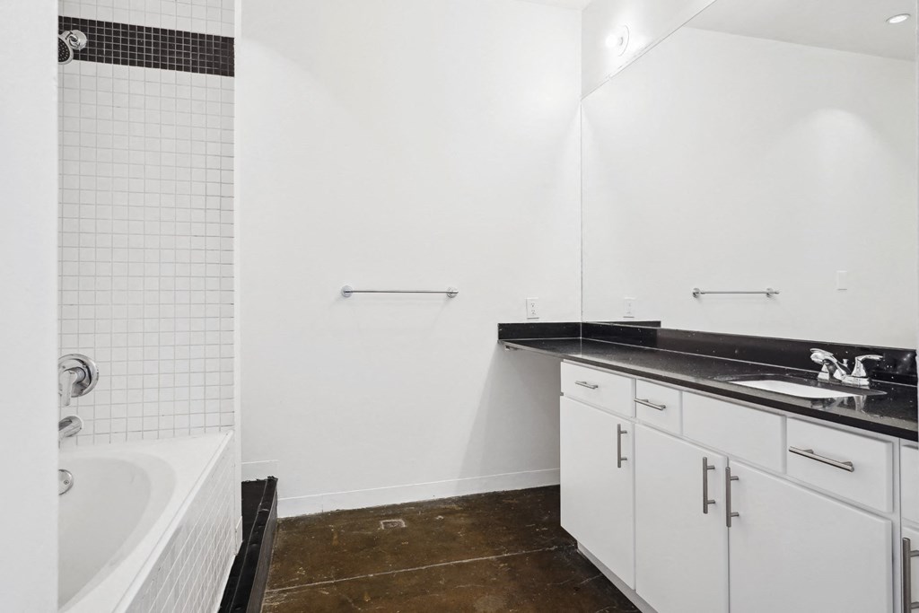 Loft bathroom at the Continental Building with white cabinets and tub | Continental Building Lofts from Deep Ellum Lofts in Dallas, TX
