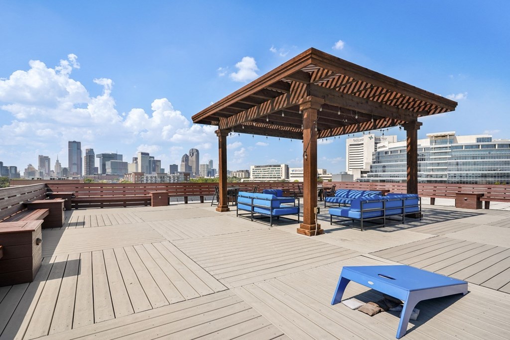 Rooftop Patio overlooking Dallas with cornhole boards and blue lounge patio couches | Continental Building Lofts from Deep Ellum Lofts in Dallas, TX