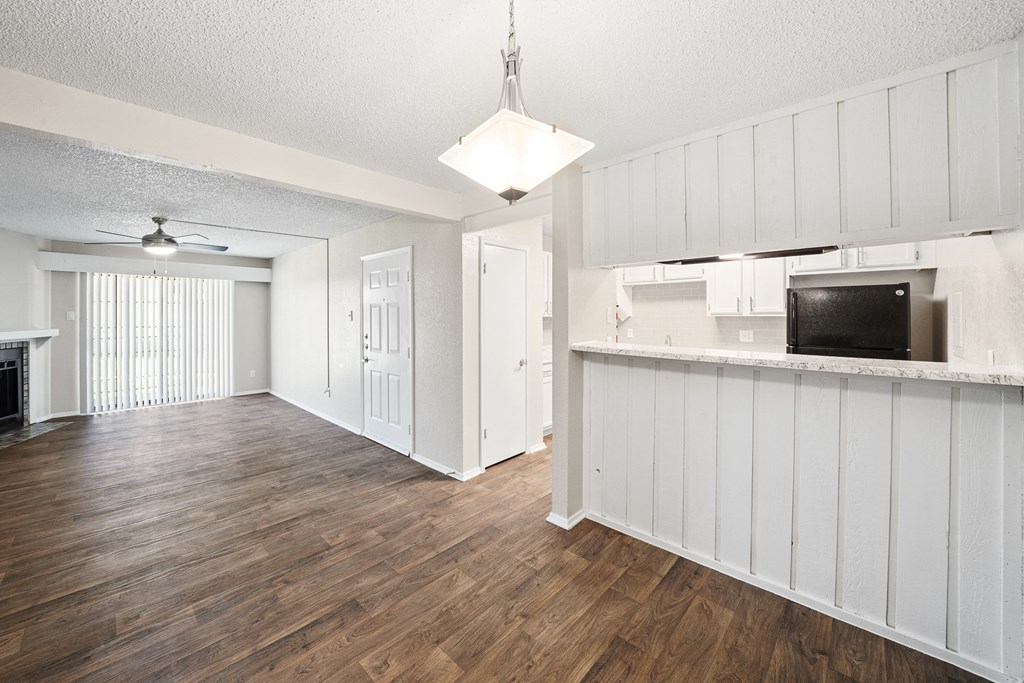 an open living room and kitchen with hardwood flooring