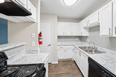 a kitchen with white cabinets and a black stove top oven