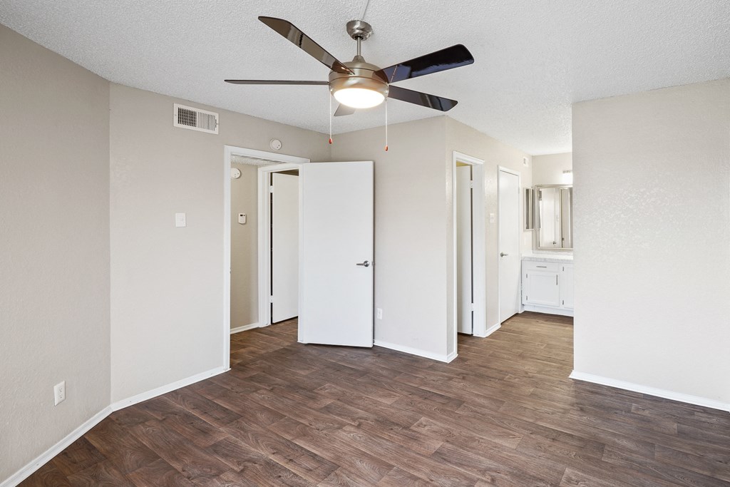 a bedroom with hardwood flooring and a ceiling fan