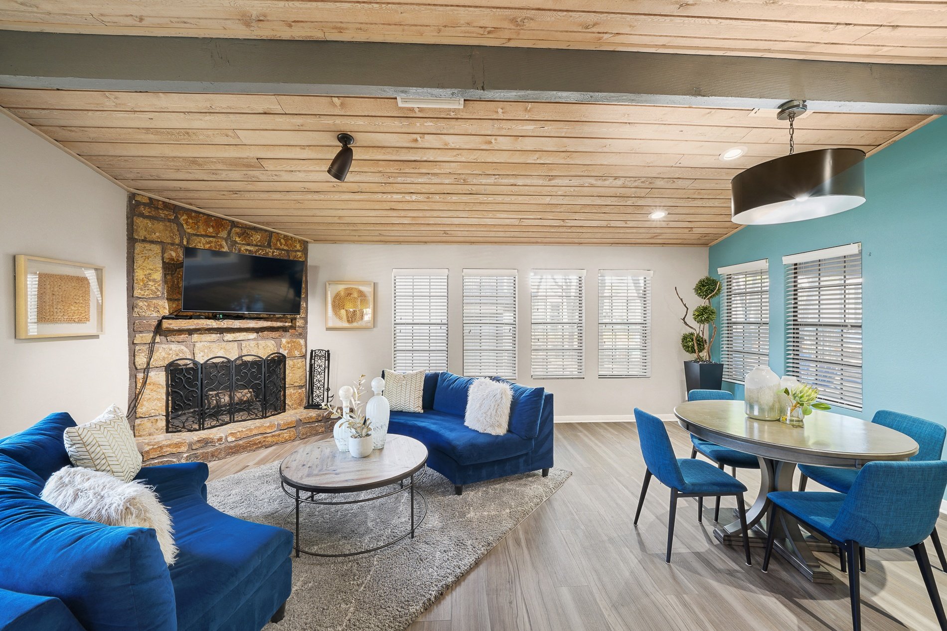 a living room with blue couches and a table and a fireplace