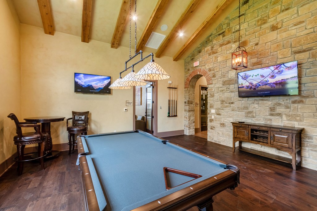 a game room with a pool table and a tv