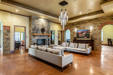 the living room has a large stone fireplace and couches