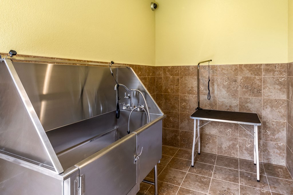 a stainless steel utility room with a sink and a chair