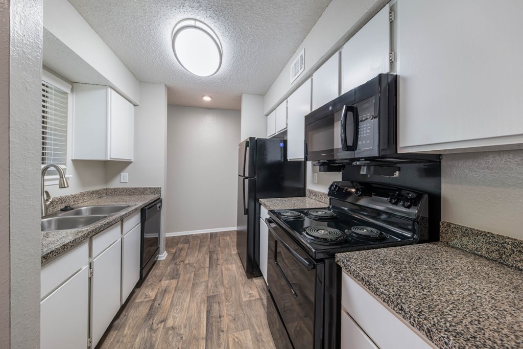 Crooked Stick kitchen with black appliances and white cabinets at Westdale Hills apartments