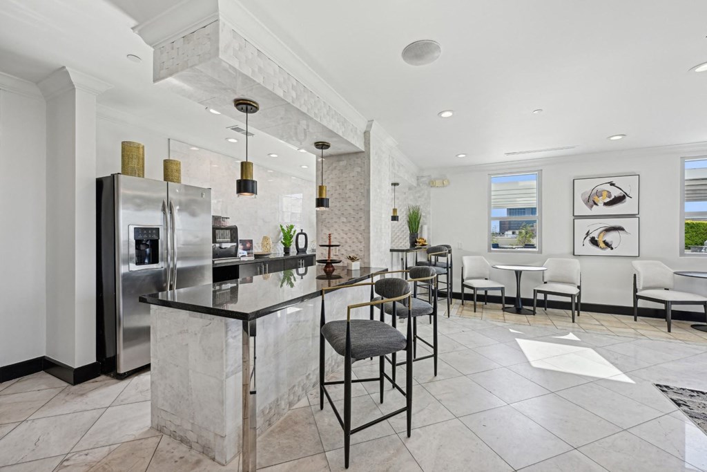 Modern community kitchen with an island and stainless steel appliances for all residents to enjoy at Dominion Post Oak apartments in Houston, TX