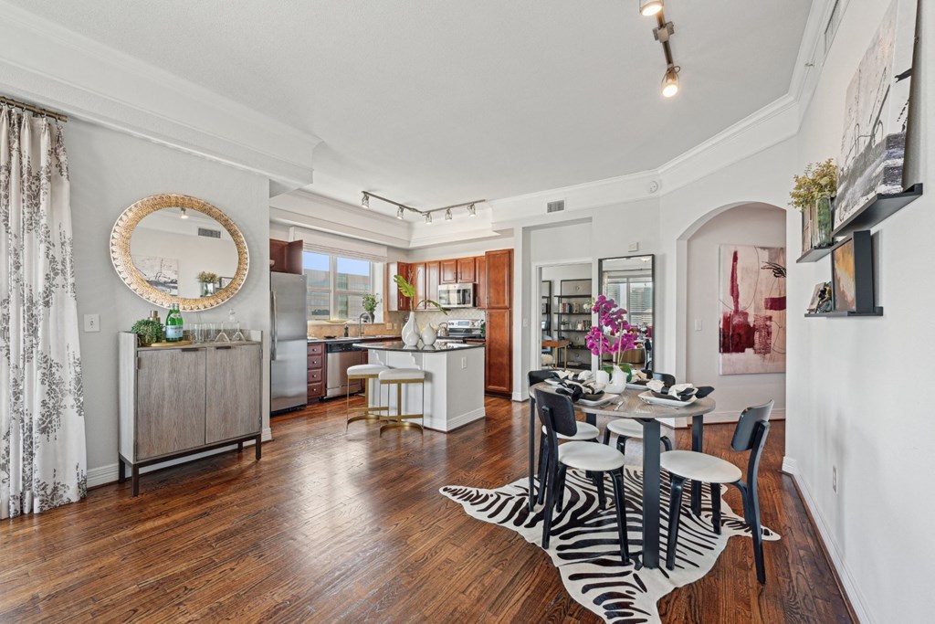 Model apartment dining room with a zebra print rug and a round mirror on the wall at Dominion Post Oak apartments in Houston, TX