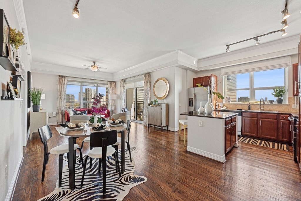 Model kitchen and dining room with a zebra print rug and under the dining table at Dominion Post Oak apartments in Houston, TX