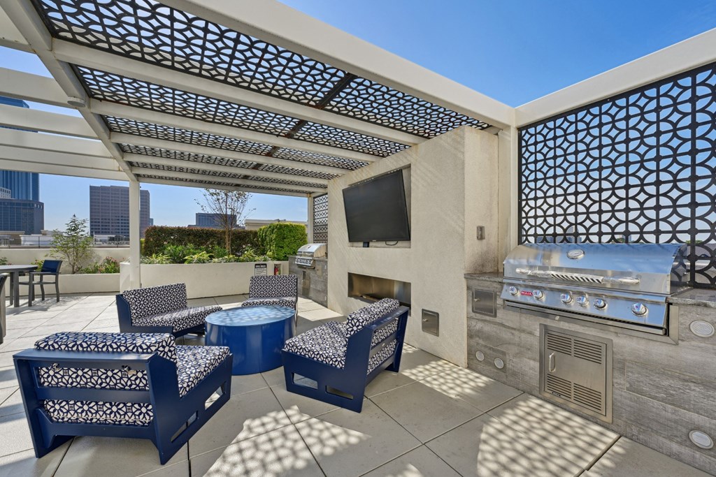 Outdoor grilling station with BBQ grill and seating at Dominion Post Oak apartments in Houston, TX