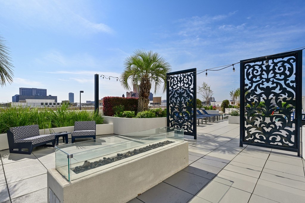 Rooftop patio with palm trees and a firepit at Dominion Post Oak apartments in Houston, TX