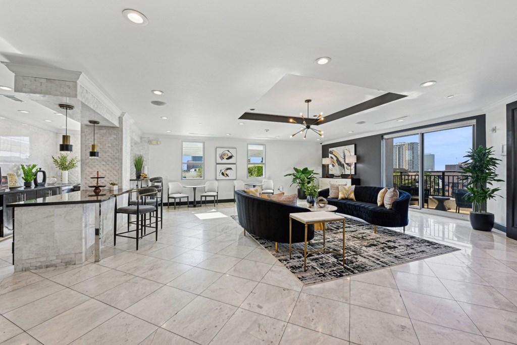 Spacious resident lounge with a kitchen area in the background at Dominion Post Oak apartments in Houston, TX