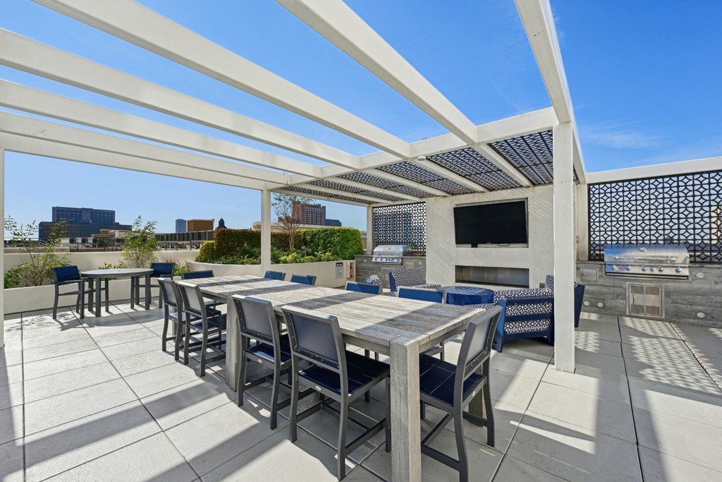 Outdoor grilling area with large dining table and two BBQ grills at Dominion Post Oak apartments in Houston, TX
