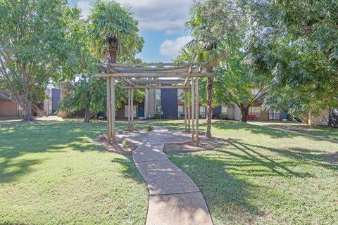 Lush trees and grass surround a paved gazebo at The Drake in Bossier City, LA