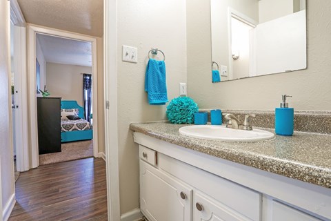 A bathroom with a white sink and blue towel at The Drake in Bossier City, LA