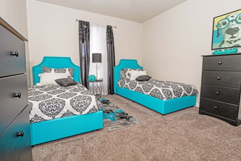 A room with two beds and a dresser at The Drake in Bossier City, LA