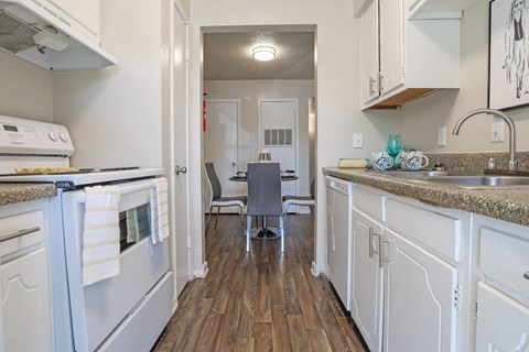 A kitchen with a white stovetop oven and cabinets at The Drake in Bossier City, LA