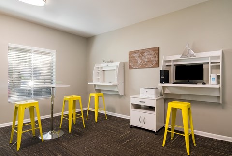 a room with stools and a desk with a computer on it