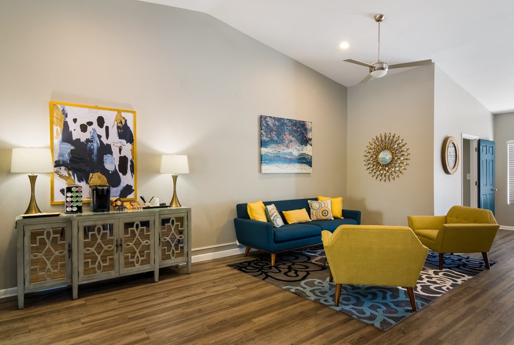 resident lounge with a blue couch and yellow chairs at Dunwoody Pointe in Sandy Springs, GA