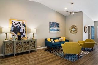 a living room with a blue couch and yellow chairs