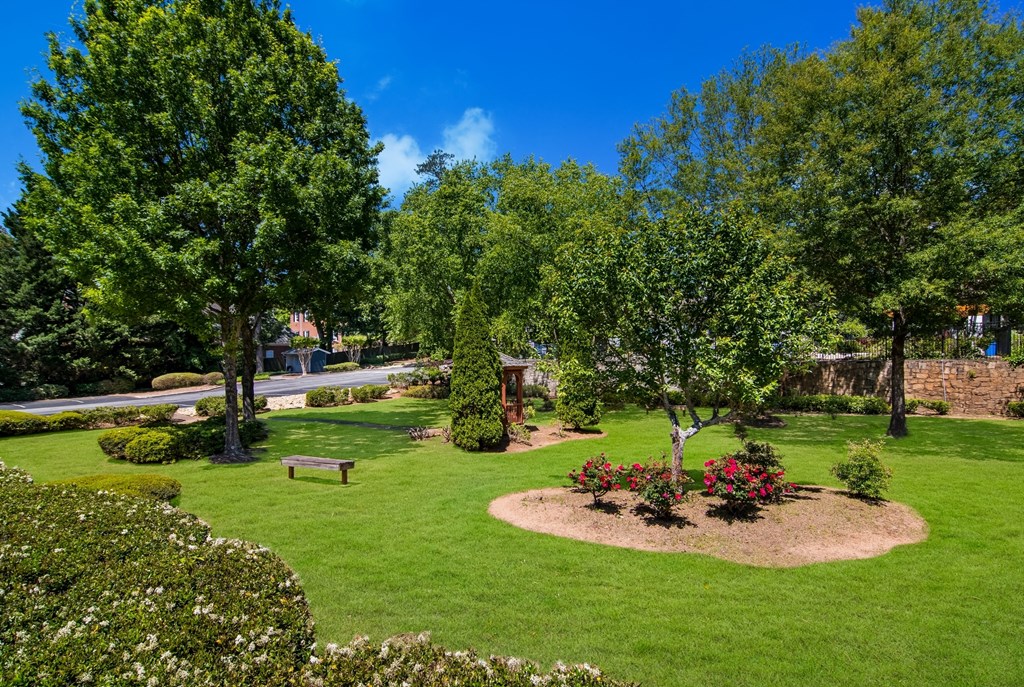 outdoor activity area with green grass and trees at Dunwoody Pointe in Sandy Springs, GA