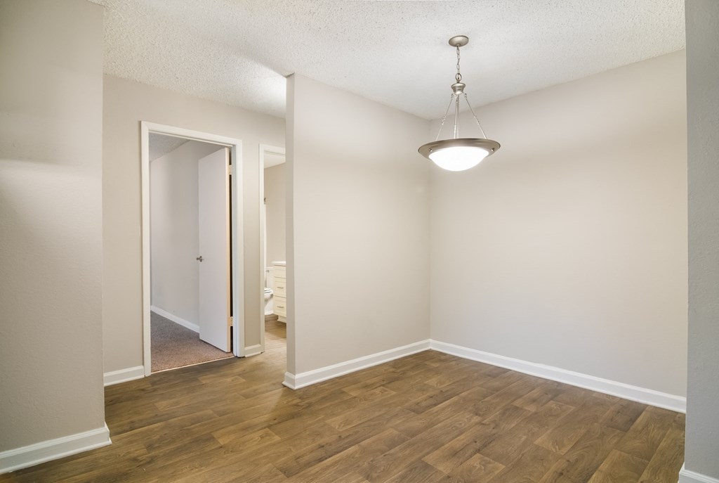 a bedroom with hardwood floors and white walls at Dunwoody Pointe in Sandy Springs, GA