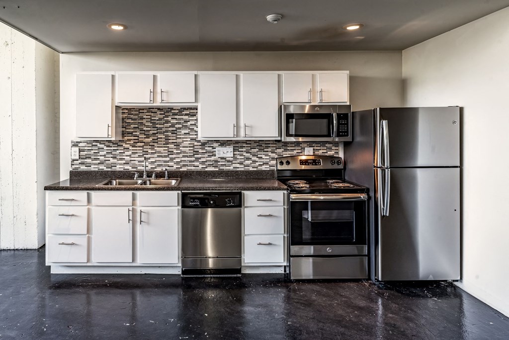 a kitchen with white cabinets and stainless steel appliances