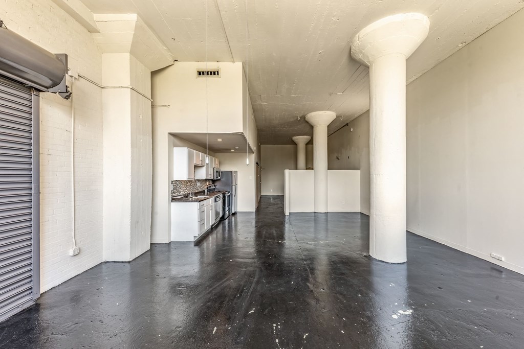 an empty room with white walls and a black floor
