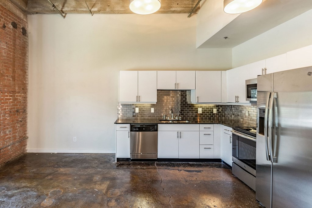 a kitchen with white cabinets and stainless steel appliances
