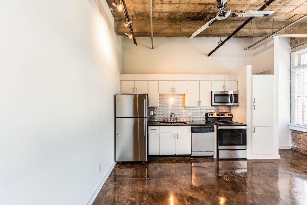 a kitchen with white cabinets and stainless steel appliances