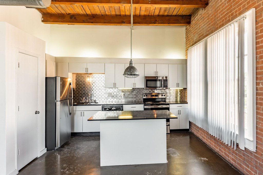 a kitchen with white cabinets and a black counter top