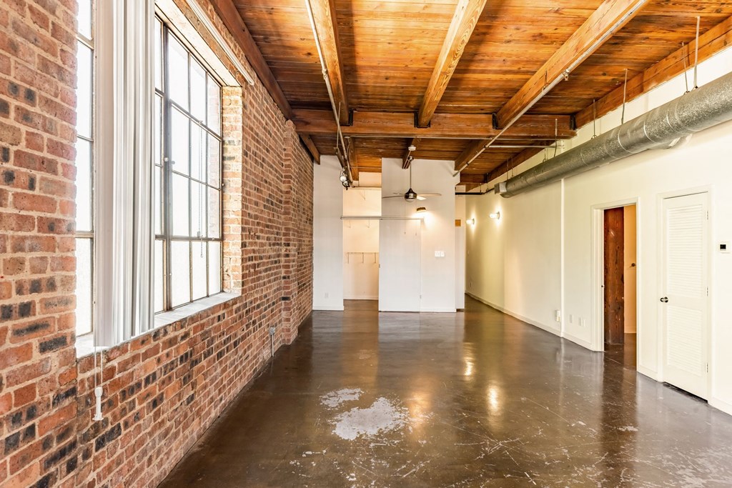an empty room with a large window and a concrete floor