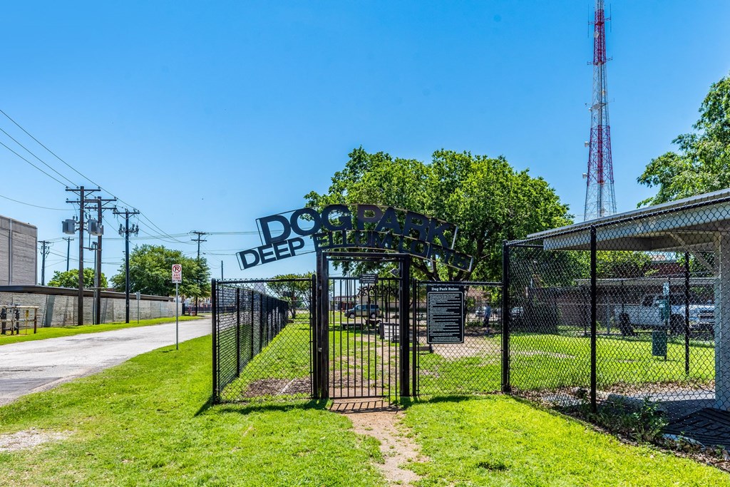 a dog park with a black gate and a sign that reads doggie deep litter
