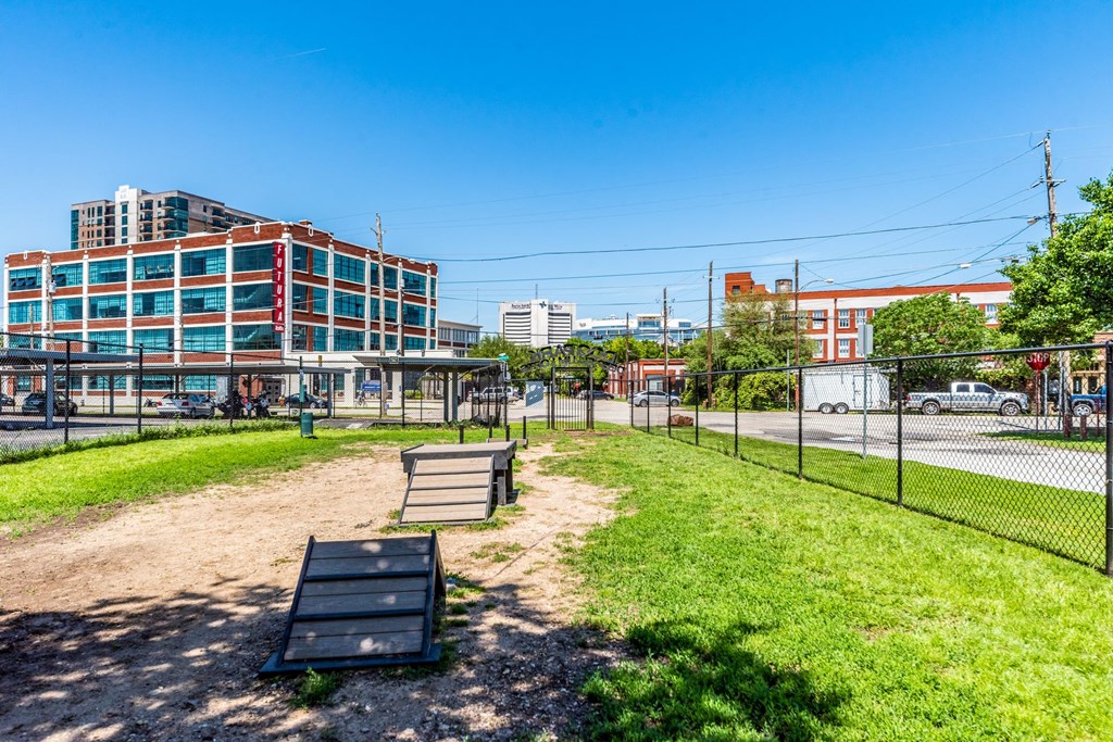 a park with a fence and a bench in front of a building