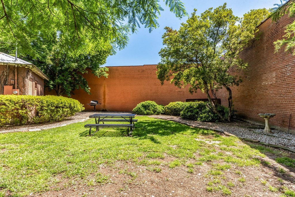 a picnic table in a grassy area next to a brick building
