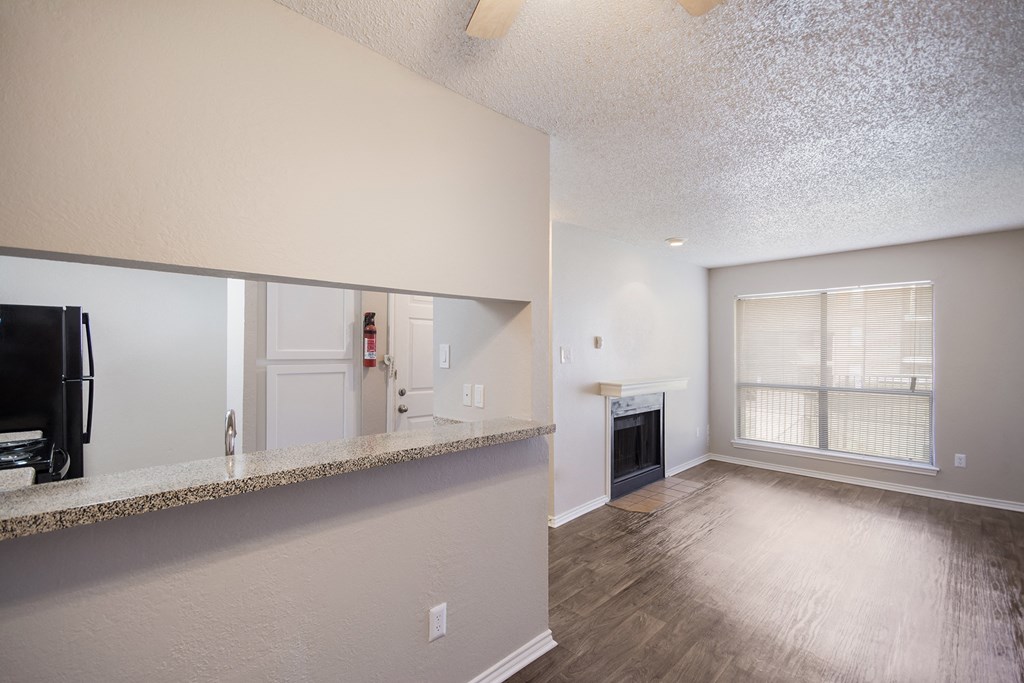 the living room and dining room of an apartment with a fireplace